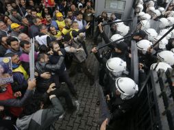 Varios manifestantes se enfrentan a la policía antidisturbios durante una protesta en contra del ataque terrorista. EFE / C. Turkel