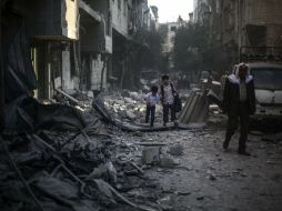 Niños caminan entre las ruinas de una casa tras un bombardeo. EFE / M. Badra