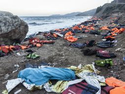El cadaver de una persona yace junto a las chaquetas salvavidas luego de un naufracio acaecido en aguas griegas. EFE / S. Donaire