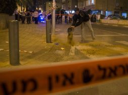 Un policía limpia la sangre que quedó en el suelo tras un apuñalamiento. AP / J. Guez