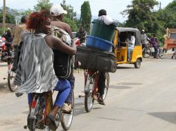 Ante la violencia, vecinos de Buyumbura huyen a bordo de sus bicicletas con todo lo que pueden cargar consigo. AP /