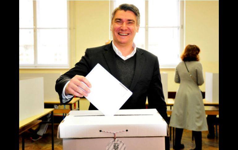 Zoran Milanovic, primer ministro de Croacia, deposita su papeleta en la urna; él es líder del Partido Social Democrático del país. EFE / I. Kupljenik