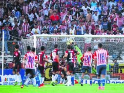 El arquero del Atlas, Miguel Fraga, no puede contener un disparo casi a la mitad del arco de parte de Marco Fabián de las Chivas (#33). MEXSPORT / A. Macías