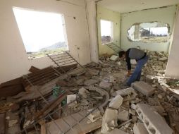 Un palestino registra entre los escombros de una de las construcciones derruidas. EFE / A. Badarneh