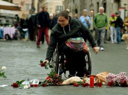 Una mujer deja flores afuera de la embajada de París en Roma para honrar a las personas que murieron en la tragedia. AFP / T. Fabi