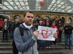 Un joven inglés muestra una imagen en donde se fusionan la torre Eiffel y un corazón como símbolo de apoyo para Francia. AFP / P. Ellis