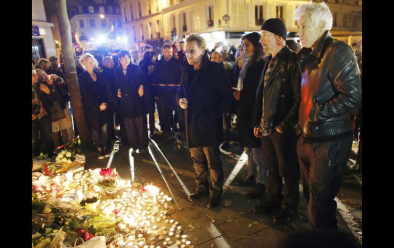 Los integrantes de U2 colocan flores a las afueras del Bataclan, uno de los lugares en donde ocurrieron los atentados. EFE / M. Christians