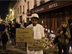 Musulmán frente al bar Le Carillon con el letrero: '¡Islam no es terrorismo!, es como esta flor. El terrorismo no tiene religión'. AFP / D. Faget
