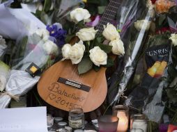 Una guitarra rodeada de flores y velas encendidas fue depositada frente a la sala de fiestas Bataclan. EFE / M. Becker