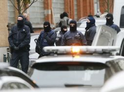 Agentes de policía antidisturbios permanecen en guardia en el distrito de Molenbeek en Bruselas mientras se realiza un cateo. EFE / O.Hoslet