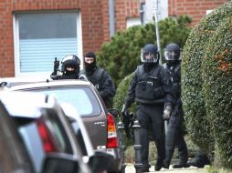 Policías montan guardia cerca de una de las viviendas registradas. EFE / R. Roeger
