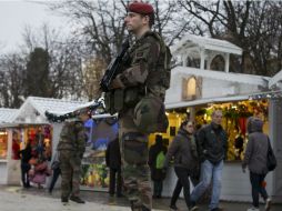 Miembros del ejército patrullan un mercado navideño montado en la Avenida Campos Eliseos, de París. EFE / I. Langsdon