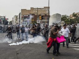 Comerciantes ambulantes que protestaban por el retiro de sus puestos son dispersados por la policía con gases lacrimógenos. EL INFORMADOR / R. Tamayo