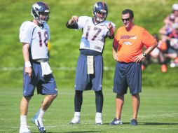 Brock Osweiler, al centro, platica con el coach de quarterbacks de los Broncos de Denver, Greg Kanpp (derecha). AP /