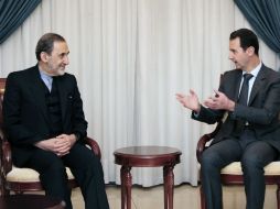 Al Asad (d) dice que tanto su Gobierno como sus amigos, consideran que eliminar el terrorismo es el paso al éxito de la paz en Siria. AP /