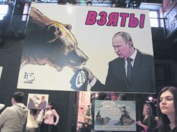 Caricatura de Vladimir Putin con un oso y un rótulo que reza: “Tras ellos (el Estado Islámico)”, en el Estudio 13 de Moscú. EFE /