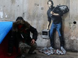 El esquivo grafitero representa a Steve Jobs, portando una bolsa negra de basura y un modelo primitivo de su computadora Macintosh. AP / M. Spingler