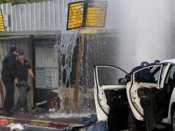 Policías inspecciona el lugar donde un palestino fue abatido tras empotrar su coche contra una parada de autobús. EFE / A. Sultan