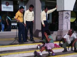 Los empledos mojaron a los indigentes para que se retiraran del comercio. ESPECIAL /