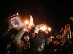 Protestantes queman imágenes de la familia real árabe en medio de las manifestaciones. EFE / M. Reza
