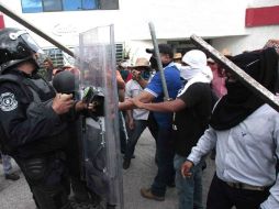 En el desalojo, comerciantes lanzan botellas y otros objetos contra policías, quienes respondieron con escudos. SUN / ARCHIVO