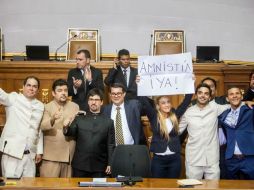 Lilian Tintori, esposa del opositor encarcelado Leopoldo López, sostiene un cartel durante la instalación de la Asamblea Nacional.  /