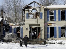 Investigadores examinan los restos calcinados para determinar qué causó la explosión e incendio que mató a una familia. AP / T. Dejak