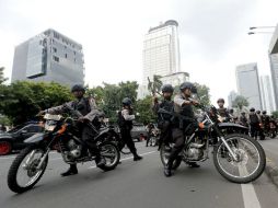 Policías acordonan el área en donde ocurrieron los hechos. EFE / B. Indahono
