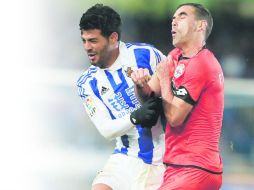 El mexicano Carlos Vela choca con Fernando Navarro, del Deportivo de la Coruña. EFE /