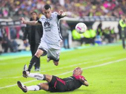 Fue un partido rudo, movido, pero al final el América se llevó los tres puntos. Aquí, Sambueza esquiva la barrida de Arévalo. EL INFORMADOR / M. Vargas