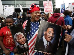 Una mujer sostiene el retrato de Martin Luther King Jr. y del presidente Mandela. AFP / J. Redmond