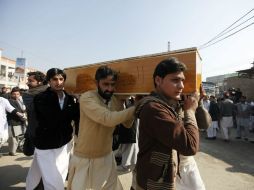 Varias personas trasladan el féretro con uno de los fallecidos del asalto talibán a la universidad Bacha Khan. EFE / B. Arbab