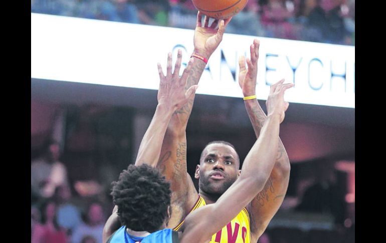La figura. LeBron James realiza un tiro al aro ante la marca de Andrew Wiggins. AP / T. Dejak