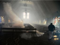Un trabajador rocía un templo en Caracas con sustancias químicas para combatir el mosquito portador del padecimiento. AFP / J. Barreto
