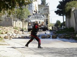Manifestantes palestinos lanzan piedras contra soldados del ejército israelí durante una protesta. EFE / A. Badarneh