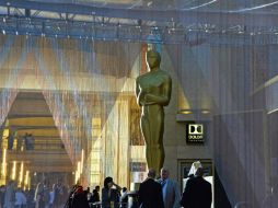 Personas caminan junto a una enorme réplica del Oscar colocada afuera del Dolby. AFP / M. Antonov