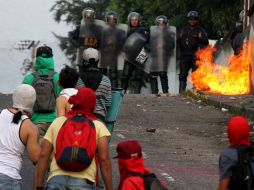 Encapuchados se enfrentan a la policía durante una protesta contra un fallo judicial que limitó las facultades del Parlamento. AFP / G. Castellano