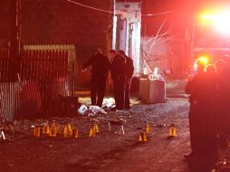 Policías registran la escena del crimen, en donde se aseguraron por lo menos veinte casquillos. AP / M. Henninger