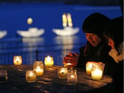 Pese al frío y la lluvia, miles de familias participan con flores y velas en el homenaje en distintos puntos del noreste del país. AFP /