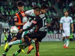 Ulises Dávila, se Santos, pierde al balón al ser confrontado por Erick Gutierrez (i) y Emmanuel Garcia (d). AFP / A. Flores