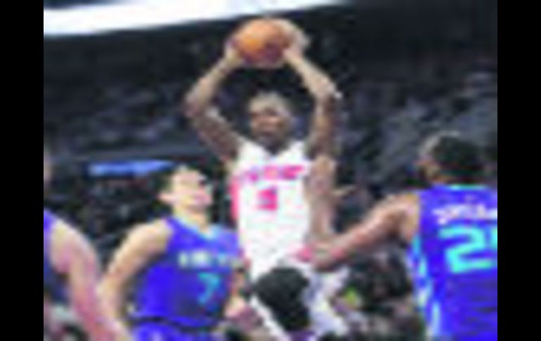 Kentavious Caldwell-Pope trata de encestar ante la marca de tres jugadores de los Hornets de Charlotte. AP / C. Osorio