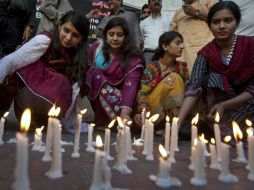 Un grupo de personas encienden velas en un homenaje a las víctimas del atentado. AP / S. Adil