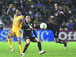 Rafael Márquez va con todo por el balón y Javier Aquino cierra los ojos como esperando un golpe. EFE /