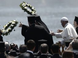 El Papa Francisco y el patriarca ecuménico Bartolomé lanzan coronas de flores en un homenaje a las víctimas de la migración. EFE / Y. Kolesidis