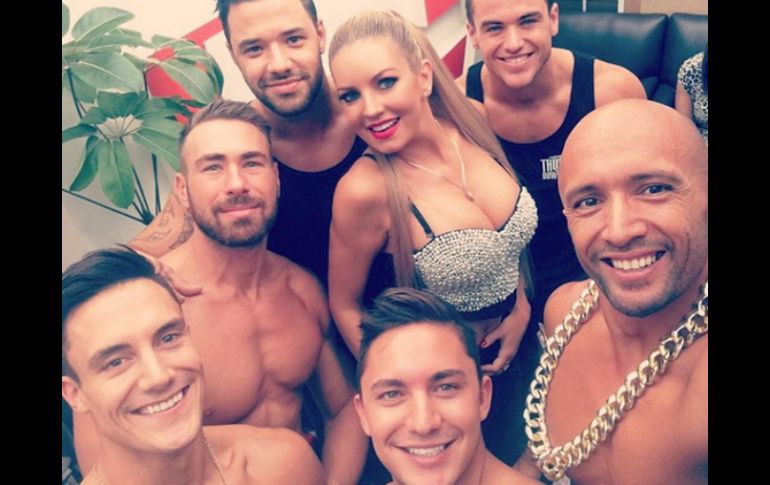 Madow aparece con una blusa escotada junto a un grupo de hombres. INSTAGRAM / @isabelmadow