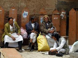 Yemeníes permanecen sentados en un mercado de la ciudad vieja de Saná. EFE / Y. Arhab