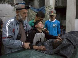 Un niño llora a un familiar muerto en el bombardeo. AFP / K. Al-Masri