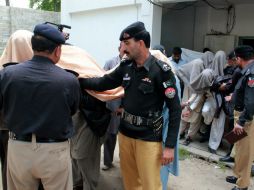 Policías escoltan a las 13 personas que fueron detenidas por el hecho a la Comisaría, en donde declararán. AP / A. Ahmed
