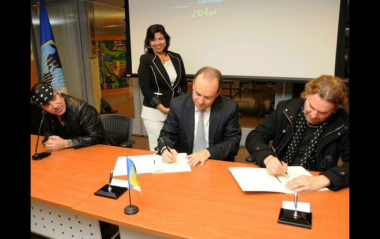 El cantante Fher Olvera y el baterista Alex González firman los acuerdos con el Banco Interamericano de Desarrollo. TWITTER / @manaoficial