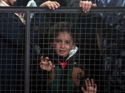 Una niña palestina espera junto con su familia su turno para entrar a territorio egipcio. AP / K. Hamra